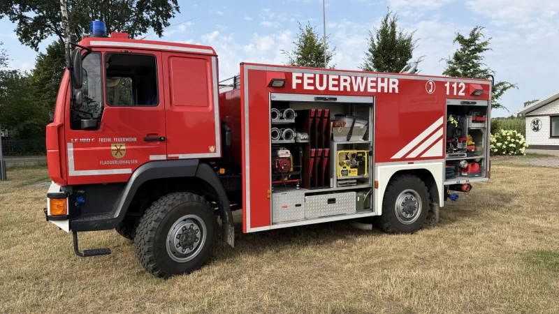 Fahrerseite des TLF 16/24 Tr mit geöffneten Geräteräumen: Schläuche, Kupplungen und tragbare Geräte in den Fächern.