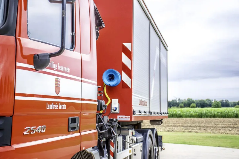 Fahrerhaus des Actros mit Aufschrift Landkreis Vechta, dahinter der Abrollbehälter.