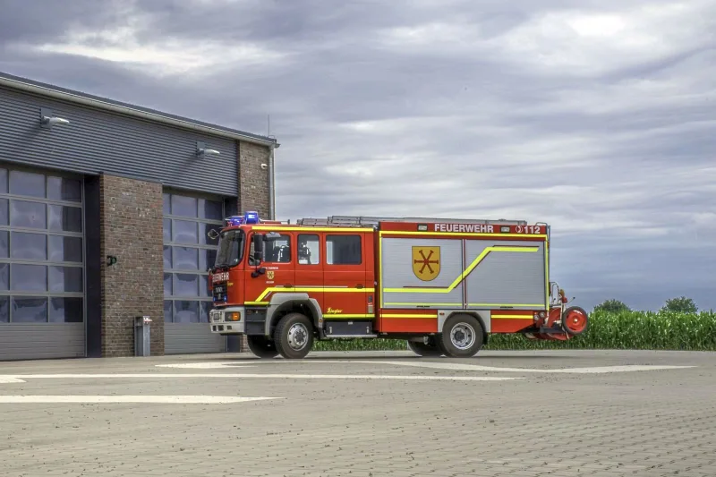 HLF 2 von der Seite vor den Toren des Feuerwehrhauses.
