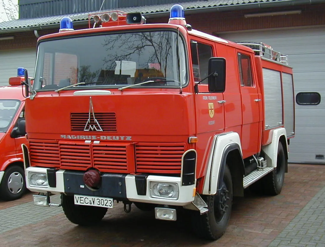 Rotes Löschgruppenfahrzeug LF 8-schwer von Magirus-Deutz, frontal vor den Toren des alten Feuerwehrhauses.