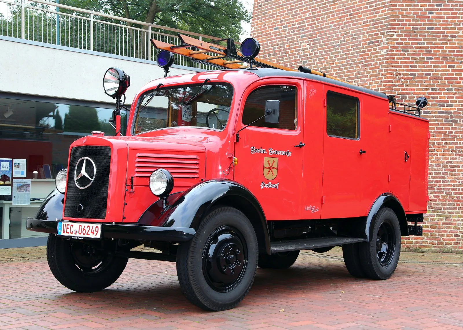 Das restaurierte LF 8-TSA in leuchtendem Rot mit schwarzen Kotflügeln und Aufschrift Freiwillige Feuerwehr Holdorf an der Tür.