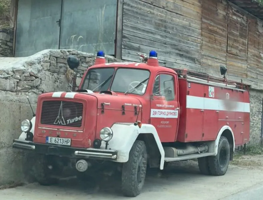 Das frühere Holdorfer TLF 16-T von Magirus-Deutz, heute mit bulgarischer Beschriftung und bulgarischem Kennzeichen vor einer Holzwand.