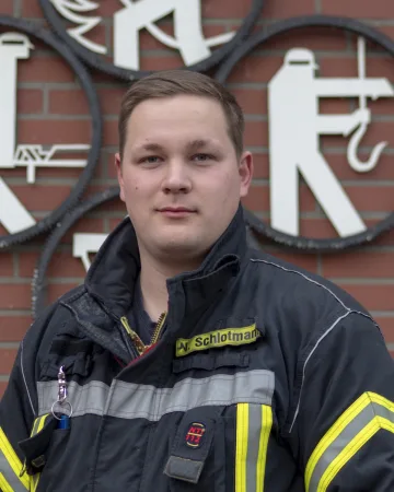 Porträt von Nico Schlotmann in Einsatzjacke mit Namensschild.