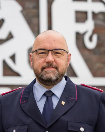 Porträt von Jens Wolters in dunkelblauer Dienstuniform.