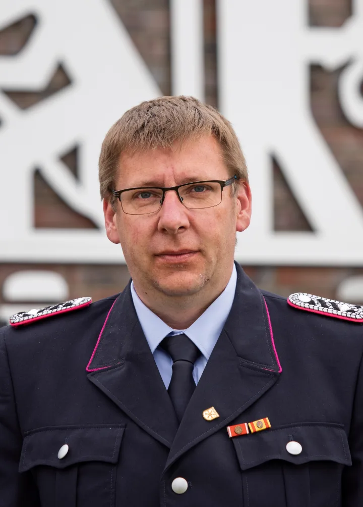Porträt von Hendrik Bocklage mit Brille in dunkelblauer Uniform.