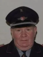 Porträt von Alfred Helms in dunkler Uniform mit Mütze.
