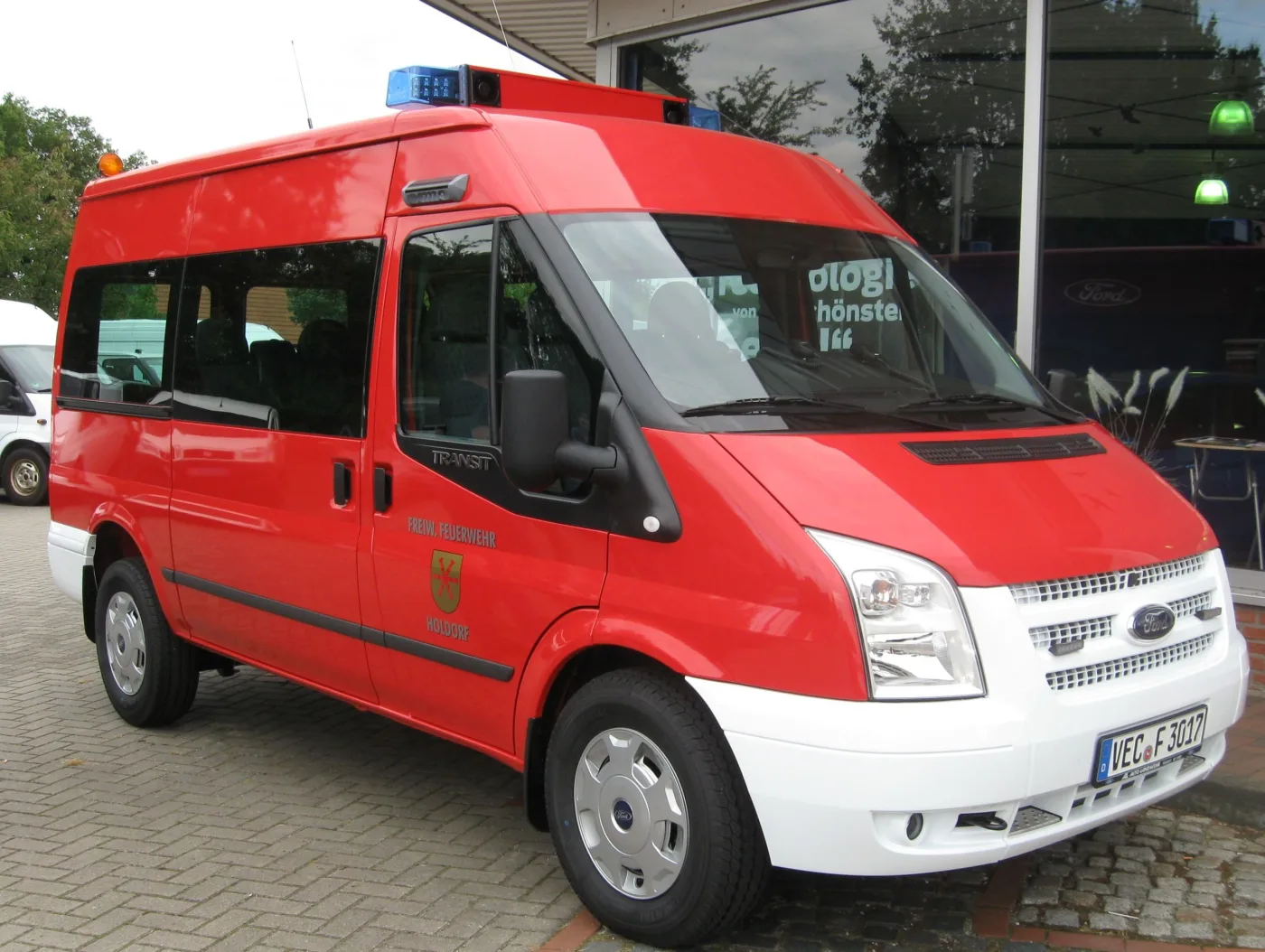 Neuer roter Ford Transit mit Blaulichtbalken und dem Holdorfer Wappen auf der Fahrertür.